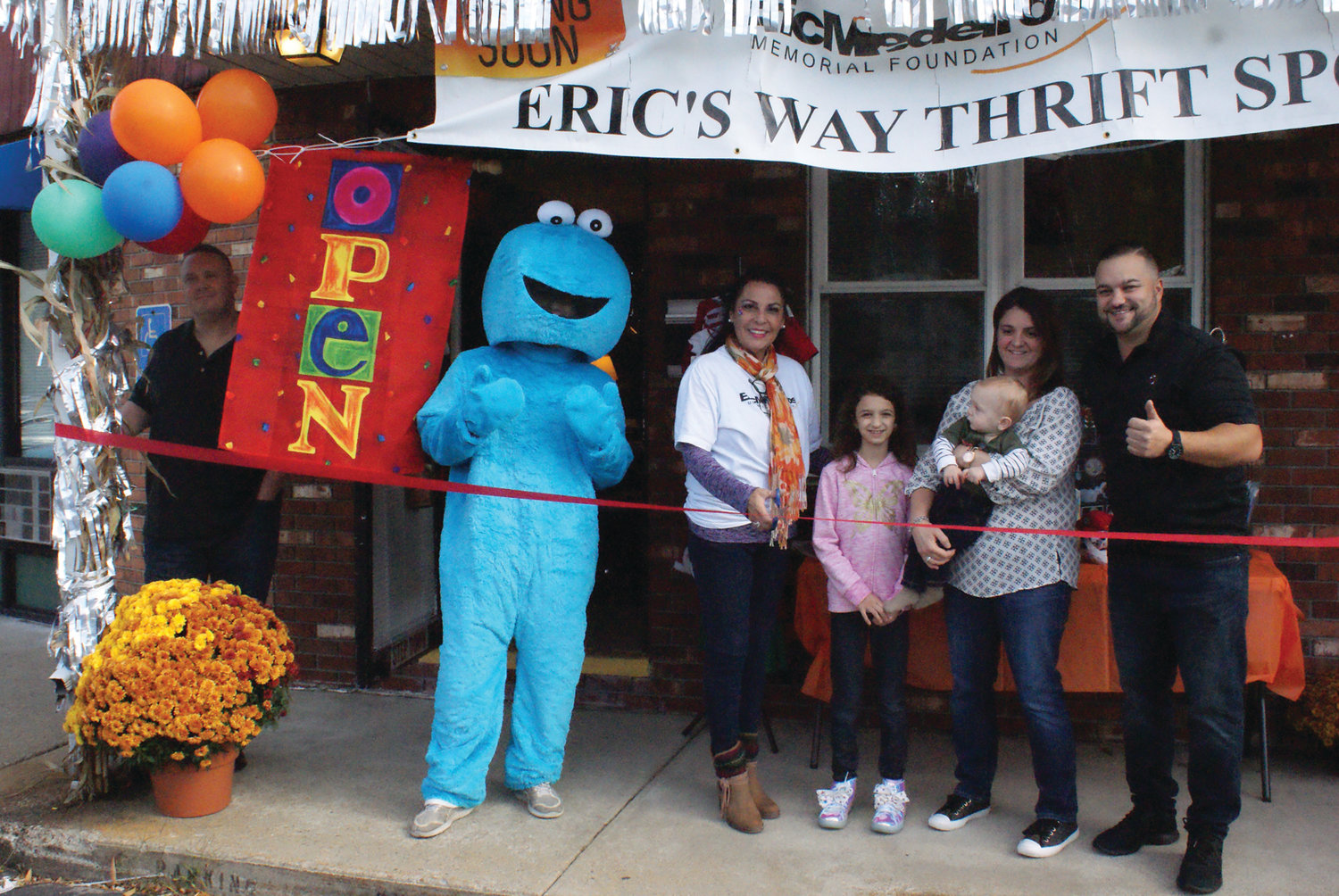 NEW BUSINESS: Eric’s Way Thrift Spot has opened at 471 Atwood Ave. and celebrated its grand opening on Oct. 26. The store sells new and gently used items to benefit the Eric Medeiros Memorial Foundation. Pictured at the ribbon-cutting ceremony are, from left, Matt Adams, Cookie Monster (Philip Page), owner Anna Casador-Saccoccio, Abby Bober, Benjamin Adams, Jeannette Saccoccio and Ward 4 City Councilman Ed Brady.